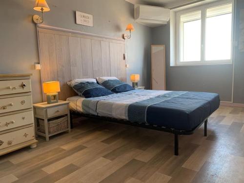 - une chambre avec un lit avec des draps bleus et deux lampes dans l'établissement Le colibri, à Lapalme