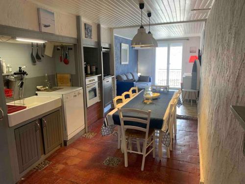 une cuisine et une salle à manger avec une table et des chaises dans l'établissement Le colibri, à Lapalme