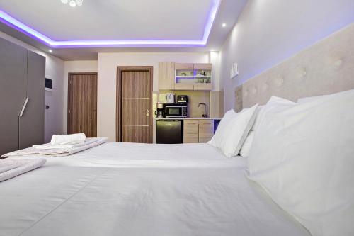 a large white bed in a room with a kitchen at Villa Dionysia Studio S5 in Alikanas