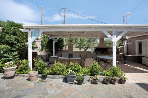 a pavilion with a table and chairs and plants at Villa Dionysia Studio S5 in Alikanas