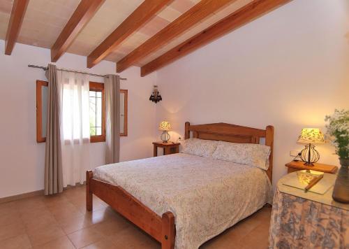 een slaapkamer met een bed, 2 lampen en een raam bij Finca Caselles de Baix 102 by Mallorca Charme in Pollença