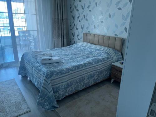 a bedroom with a bed with a blue comforter at Eryaman, Wide Luxury Concept in Etimesut
