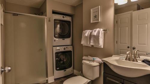 a bathroom with a washing machine and a washer and dryer at Majestic Sun 1006B in Destin