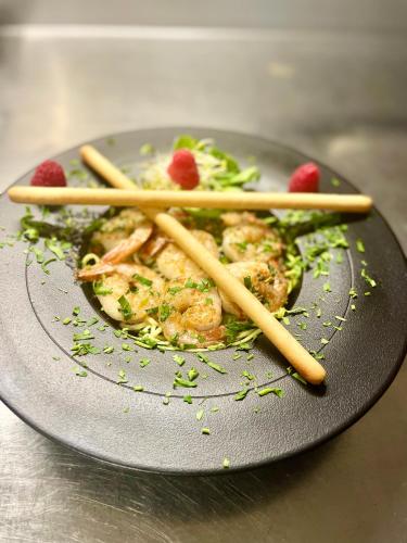 a plate of food with shrimp and vegetables with chopsticks at Piano in Nowy Sącz