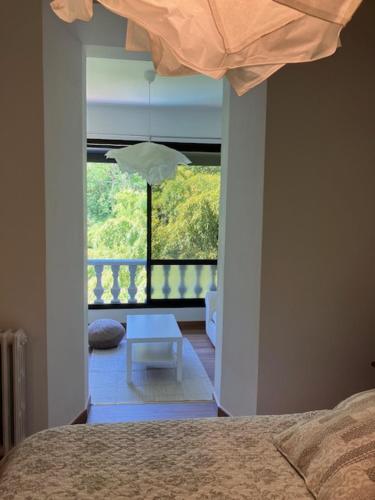 a bedroom with a bed and a table in front of a window at L'AUBERGE DE LA GOUTILLE in Capvern