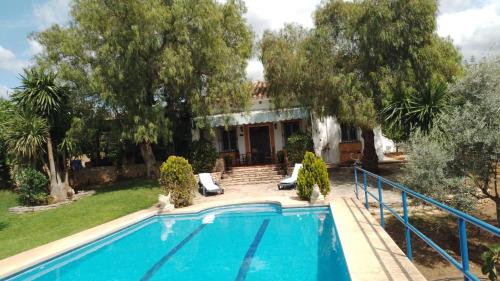 a villa with a swimming pool in front of a house at Casa Rural El Olivar Ronda in Arriate