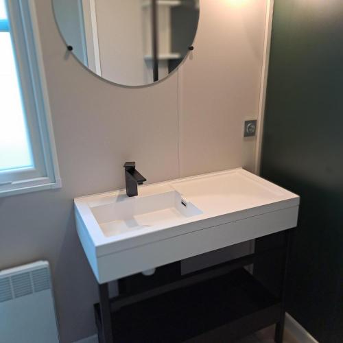 a bathroom with a white sink and a mirror at Camping Baalse Hei in Turnhout