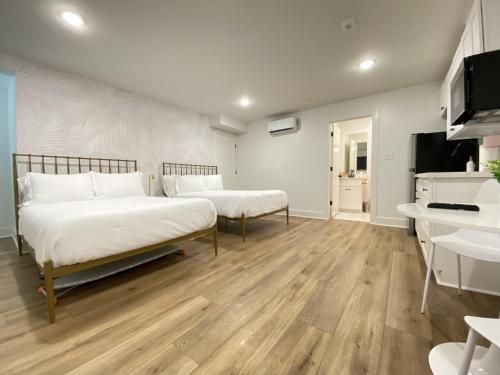 2 camas en una habitación con suelo de madera en Tropical Springs Studio Apartment Two Queen Beds, en Galveston