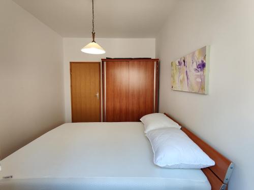 a bedroom with a bed and a wooden cabinet at Biuk Apartments in Novi Vinodolski