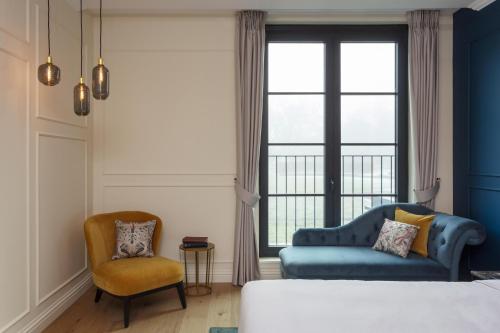 a bedroom with a bed and two chairs and a window at SCHLOSS Roxburghe, part of Destination by Hyatt in Kelso