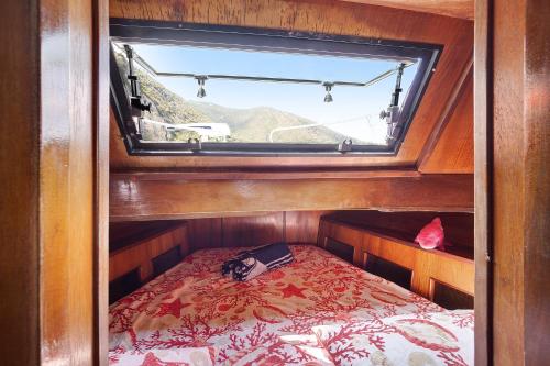 Habitación pequeña con cama y ventana en Aloha Jak's Boat, en Alassio