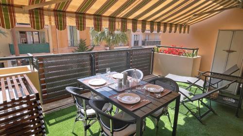 - une table et des chaises sur une terrasse avec une table et des chaises dans l'établissement Regina - Victoria, à Sainte-Maxime