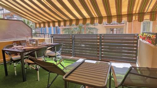 a patio with a table and chairs and a screen at Regina - Victoria in Sainte-Maxime