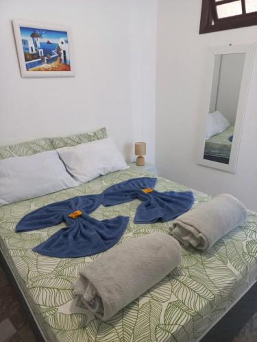 Una cama con toallas y almohadas encima. en Suíte e Apartamento Angra dos Reis, en Angra dos Reis