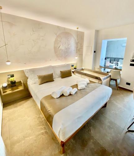 a bedroom with a large bed with towels on it at Meravigghia Suites Cefalù in Cefalù