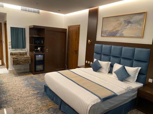 فايف بالم الفندقية في الرياض: غرفة نوم مع سرير كبير مع اللوح الأمامي الأزرق