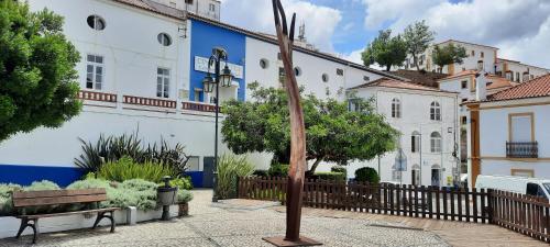 a bench in a courtyard in front of a building at Casa Esmar in Odemira