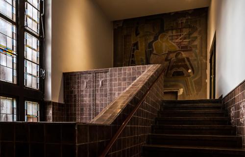 a staircase in a building with a painting on the wall at Hotel Stadtpalais in Cologne