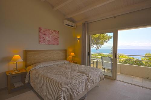 a bedroom with a bed and a view of the ocean at Agali Hotel Paxos in Gaios