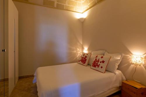 a bedroom with a white bed with two pillows on it at Casa Conte Pio in Marettimo