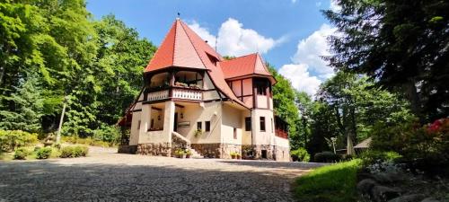 a large house with a turret on a driveway at Rezydencja Lawendowe Wzgórze in Zachełmie