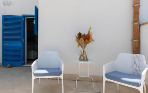 two chairs and a table with a vase of flowers at Casa Conte Pio in Marettimo