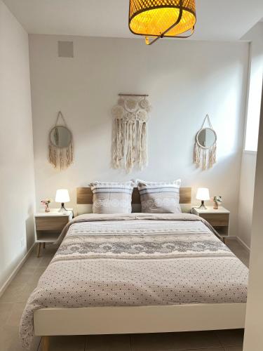 une chambre avec un grand lit et deux lampes dans l'établissement Chez Nonno, à Colmar