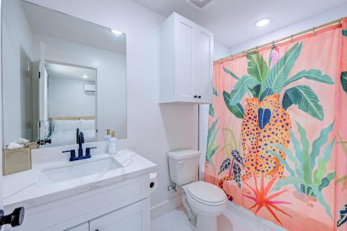 a bathroom with a toilet and a shower curtain at Cheetah Crush Studio Apartment in Galveston