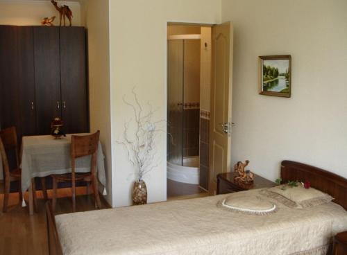 a bedroom with a bed and a table and a bathroom at Sinay Hotel in Poltava