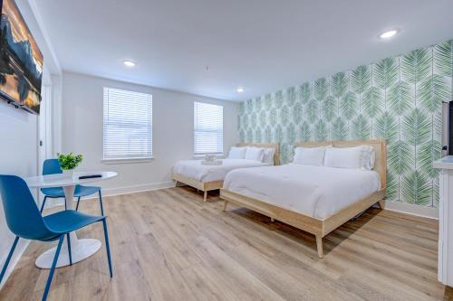 een slaapkamer met 2 bedden, een bureau en een stoel bij Beach House Paradise Studio Apartment 2 Beds in Galveston