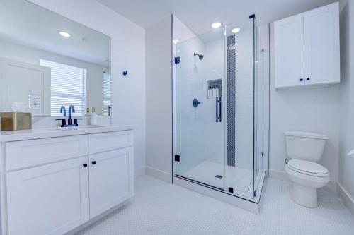 a white bathroom with a shower and a toilet at Beach House Paradise Studio Apartment 2 Beds in Galveston