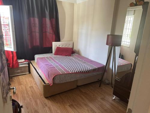 Dormitorio pequeño con cama con edredón púrpura en Квартира в Kultur 2+1 en Antalya