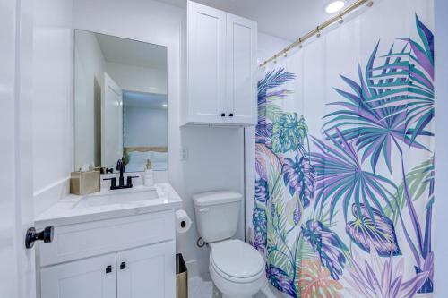 a bathroom with a toilet and a sink and a shower curtain at Caribbean Sea Studio Apartment in Galveston