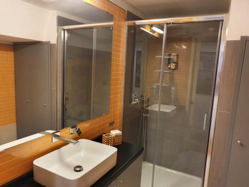 La salle de bains est pourvue d'un lavabo et d'une douche en verre. dans l'établissement La Dimora dei Reali, à Naples
