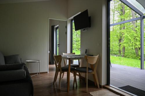 a living room with a table and chairs and a window at Domki Karpatia BB in Bielsko-Biala