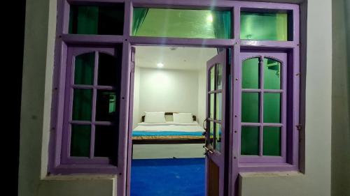 une porte menant à une chambre avec un lit dans une pièce dans l'établissement The Indian Kargil, à Kargil