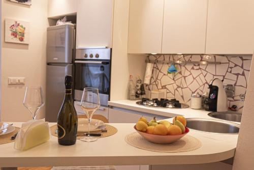 - une cuisine avec un bol de fruits et une bouteille de vin dans l'établissement Casa Bel, Bologna By Short Holidays, à Bologne