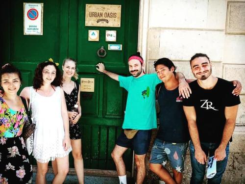een groep mensen die voor een groene deur staan bij Urban Oasis Hostel in Lecce