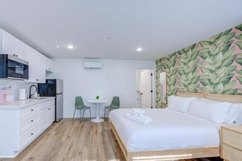 a bedroom with a large white bed and a kitchen at Beverly Hills Studio Apartment 2 Queen Beds in Galveston