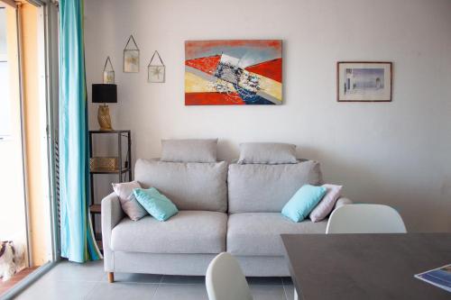 a living room with a couch and a painting on the wall at Appartement Miramar in Banyuls-sur-Mer