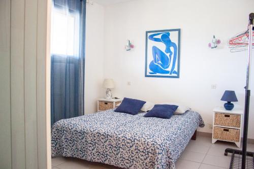 a bedroom with a bed with blue pillows on it at Appartement Miramar in Banyuls-sur-Mer