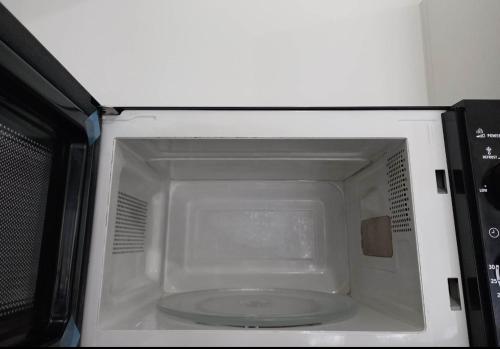 a microwave with its door open in a kitchen at SM Bicutan Rooms in Manila