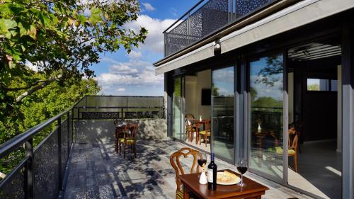uma varanda com portas de vidro e uma mesa e cadeiras em 718 Rufino Petit Hotel em Mendoza
