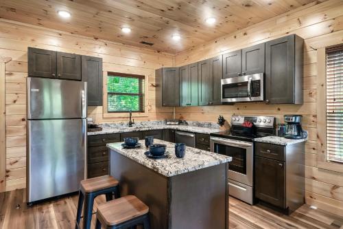 uma cozinha com electrodomésticos de aço inoxidável e paredes de madeira em Entire cabin in Sevierville, Tennessee em Sevierville