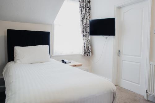 a bedroom with a white bed and a window at San Clu Hotel, Bar & Brasserie in Ramsgate