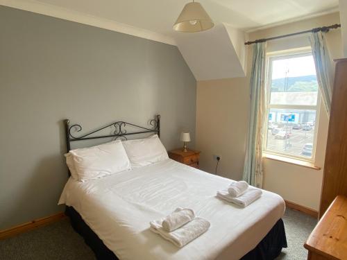 a bedroom with a bed with two towels on it at 2a Ardaravan Square in Buncrana