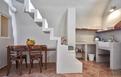 a kitchen and dining room with a table and chairs at Arvanitis Cave Village in Akrotiri