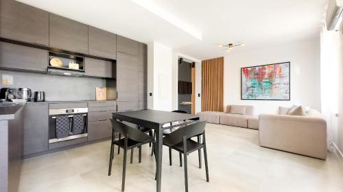 Il dispose d'une cuisine et d'un salon avec une table et des chaises noires. dans l'établissement Le Riviera by Winsome Destination, à Cannes