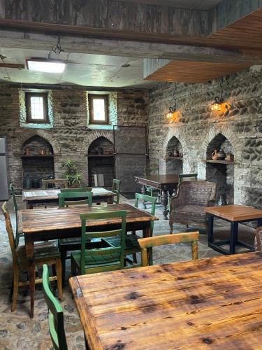 un restaurante con mesas y sillas y una pared de piedra en Guest House Savane, en Gori