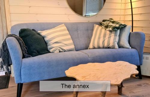 a blue couch with pillows on it in a room at Ekornredet (The Squirrel Nest) in Kongsberg